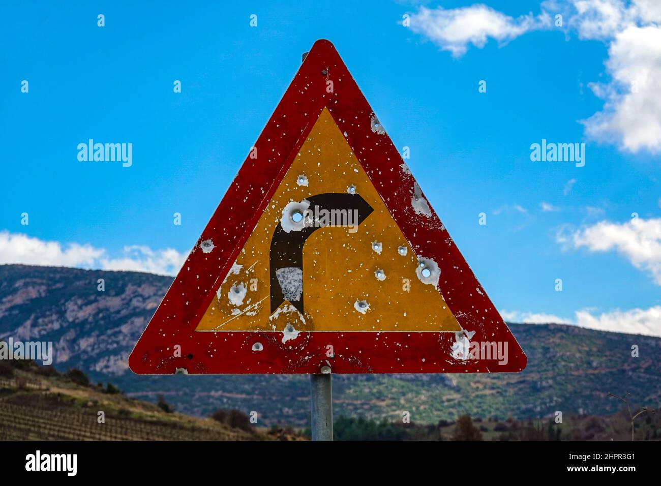 Curva in segnaletica con i fori bullet, il piccolo villaggio di montagna di Kefalari, Peleponesse, Grecia Foto Stock