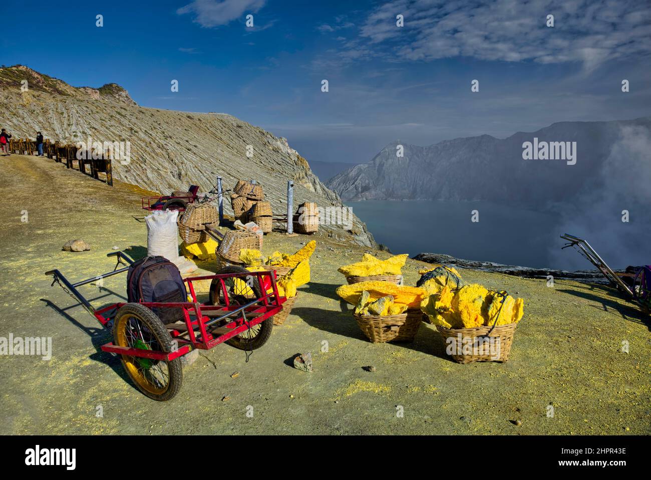Anche la vista dei minatori di zolfo che salgono e scendono fino al cratere è incredibile. Un uomo mette circa 10 kg di pietra giallastra nel suo cesto Foto Stock