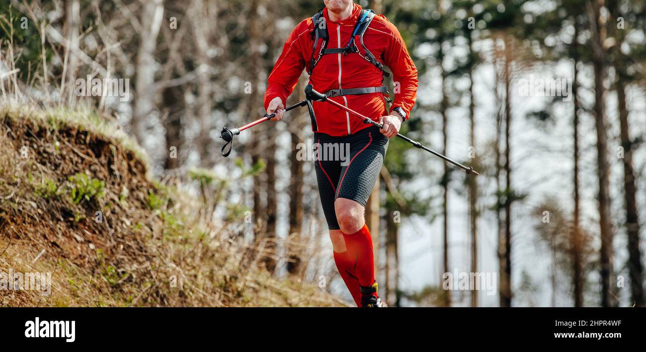 runner maschio con racchette da trekking corsa foresta Foto Stock