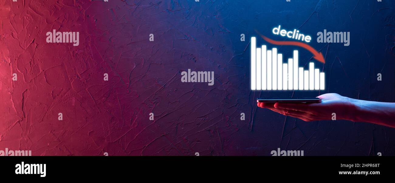 Uomo d'affari che tiene i grafici olografici e stock.declinare, diminuire, giù, cadere. Statistica aziendale. Carriera, soldi, concetto di successo. Regressione, critico Foto Stock