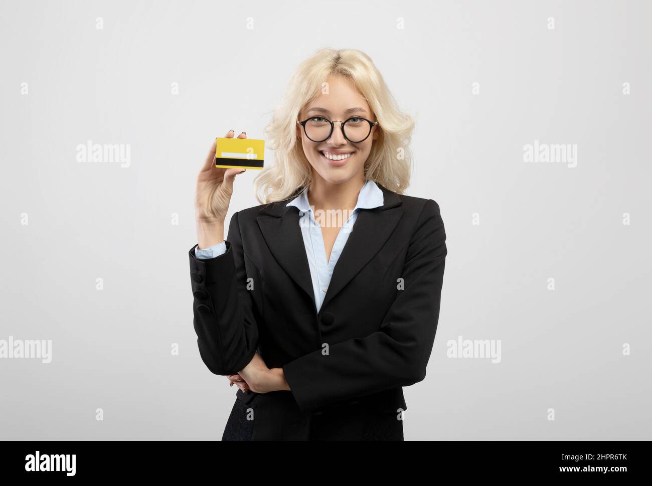 Eccitata la banca donna che tiene la carta di credito e sorride alla macchina fotografica, consigliando trasferimenti veloci di denaro Foto Stock