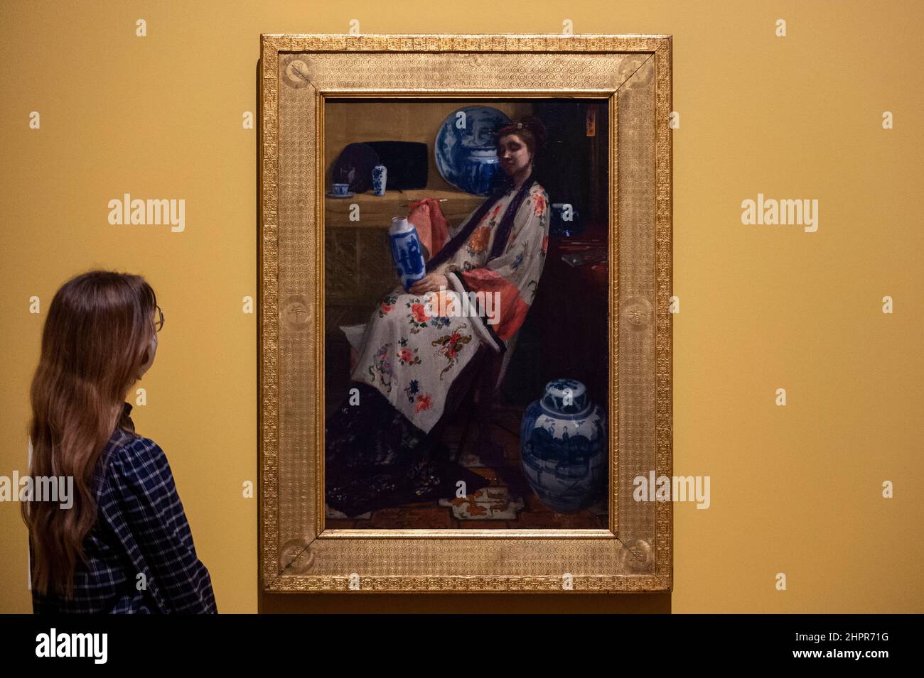 Londra, Regno Unito. 23 febbraio 2022. Una donna vede “Viola e Rosa: La Lange Leizen dei sei marchi”, 1864, di James McNeill Whistler. Anteprima di “Whistler’s Woman in White: Joanna Hiffernan”, la prima mostra a esaminare l’importante ruolo svolto dal modello irlandese Joanna Hiffernan di James McNeill Whistler. Oltre 70 opere sono alla Royal Academy of Arts dal 26 febbraio al 22 maggio 2022. Credit: Stephen Chung / Alamy Live News Foto Stock
