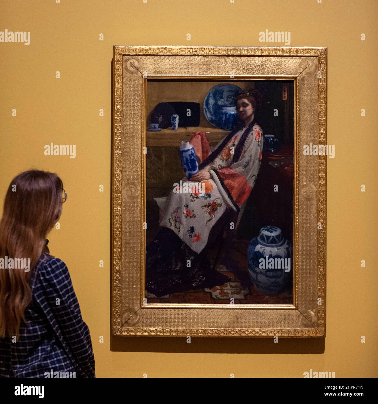 Londra, Regno Unito. 23 febbraio 2022. Una donna vede “Viola e Rosa: La Lange Leizen dei sei marchi”, 1864, di James McNeill Whistler. Anteprima di “Whistler’s Woman in White: Joanna Hiffernan”, la prima mostra a esaminare l’importante ruolo svolto dal modello irlandese Joanna Hiffernan di James McNeill Whistler. Oltre 70 opere sono alla Royal Academy of Arts dal 26 febbraio al 22 maggio 2022. Credit: Stephen Chung / Alamy Live News Foto Stock