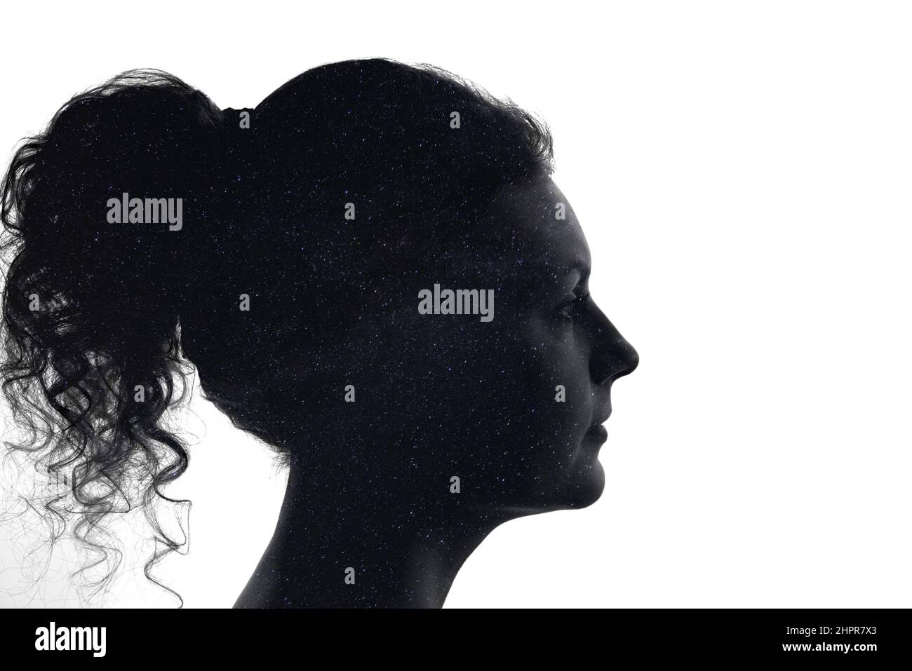 Silhouette del volto di una donna piena di cielo stellato notturno, modo lattiginoso, il concetto di stabilità psicologica e di auto-consapevolezza. Foto Stock