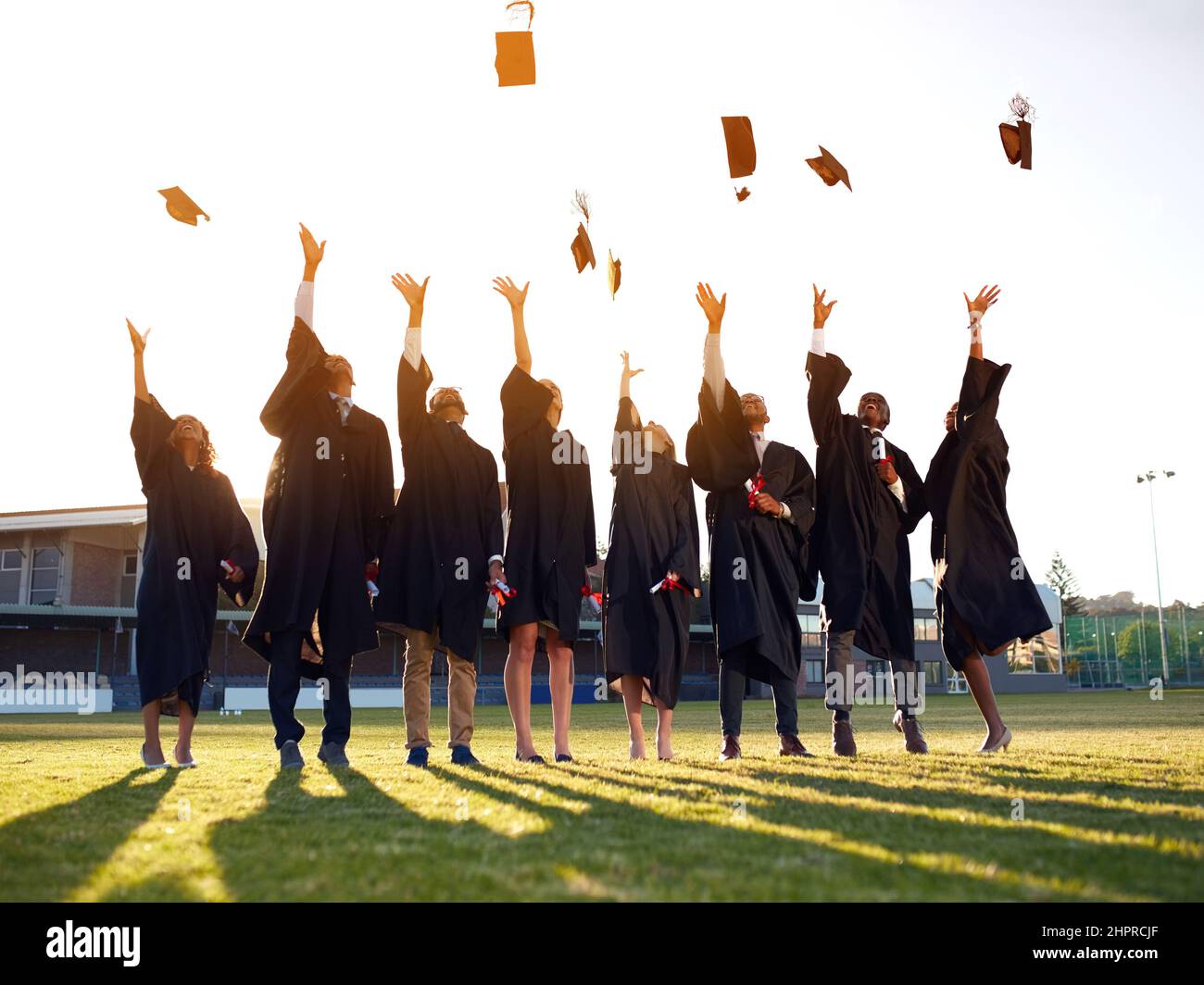 Il theyve ha raggiunto la fine dei loro anni accademici. Shot di un gruppo di studenti universitari che gettano il cappello in aria il giorno della laurea. Foto Stock