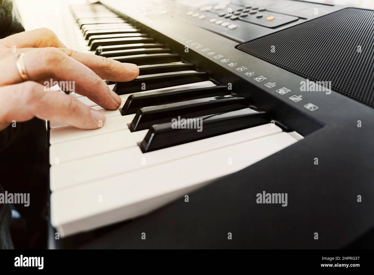 Mani maschili che suonano il sintetizzatore elettrico pianoforte digitale, le dita premono i tasti. Musicista uomo pianista accompagnamento su tastiere in bianco e nero a c Foto Stock