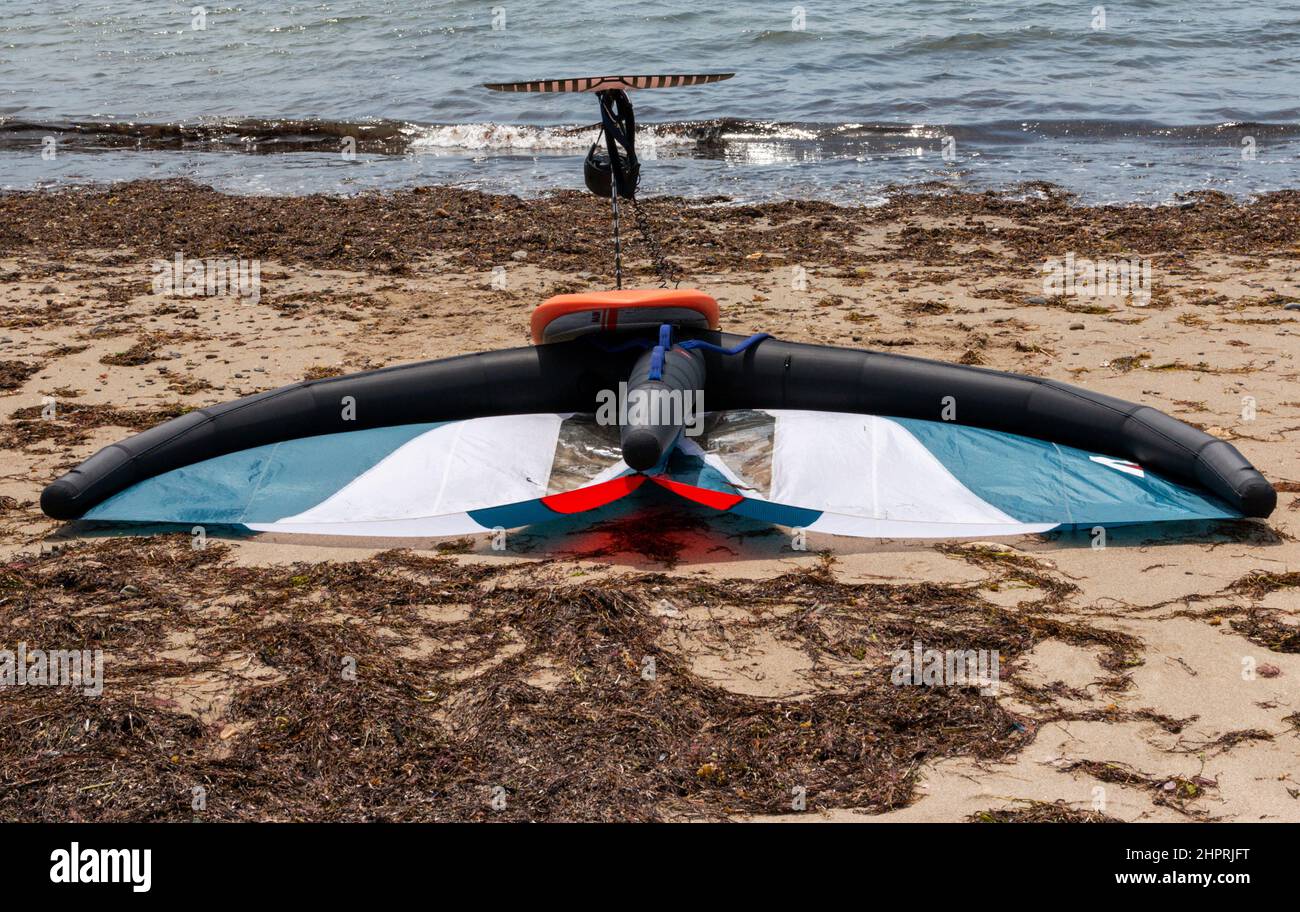 Kite board sdraiato sulla sabbia vicino alla baia Foto Stock