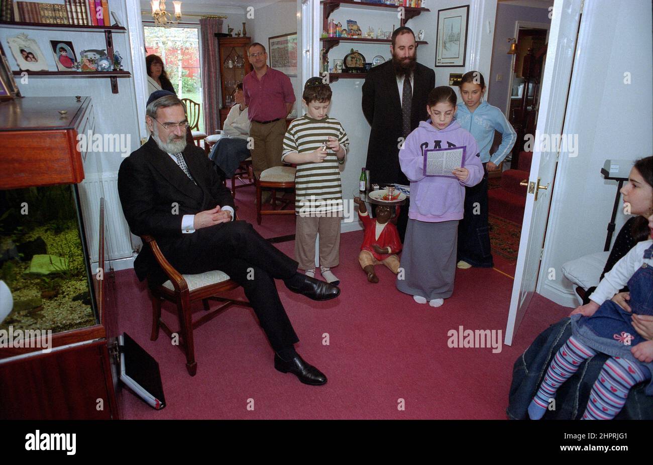 Il Rabbino Capo Jonathan Sacks è stato ospite d'onore per la celebrazione del 25th anniversario della Congregazione Ebraica di Solihull. Durante la sua visita incontrò bambini nella sala di una famiglia della congregazione. Parla in modo informale ai giovani ragazzi ebrei del loro lavoro realizzato al Cheder della sinagoga (aula), ministro della congregazione Rabbi Yehuda Pink guarda avanti. Ha parlato durante il servizio religioso il 27th ottobre 2002.il sindaco di Solihull Cllr. Kate Wild partecipò e fu presentato con un bouquet da Cheder allievo di 13 anni Zipporah Gershon Foto Stock