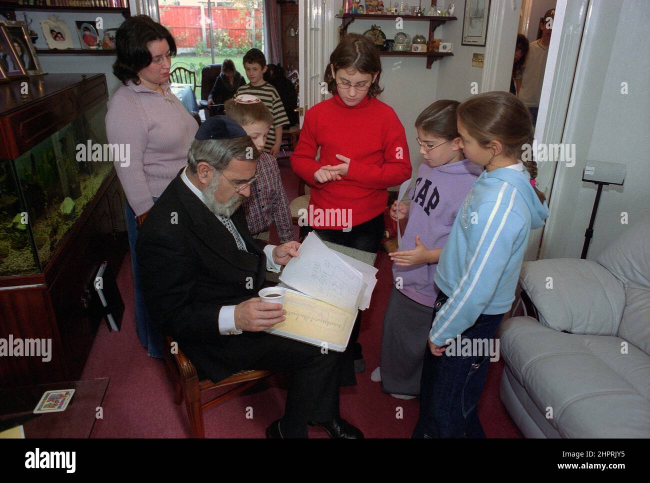 Il Rabbino Capo Jonathan Sacks è stato ospite d'onore per la celebrazione del 25th anniversario della Congregazione Ebraica di Solihull. Durante la sua visita incontrò bambini nella sala di una famiglia della congregazione. Parla in modo informale ai giovani ragazzi ebrei del loro lavoro realizzato al Cheder della sinagoga (aula), ministro della congregazione Rabbi Yehuda Pink guarda avanti. Ha parlato durante il servizio religioso il 27th ottobre 2002.il sindaco di Solihull Cllr. Kate Wild partecipò e fu presentato con un bouquet da Cheder allievo di 13 anni Zipporah Gershon Foto Stock