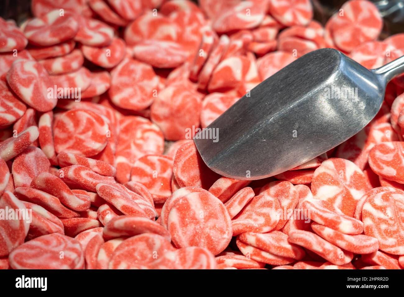 Caramelle dolci rosse in un negozio di caramelle con paletta in metallo Foto Stock