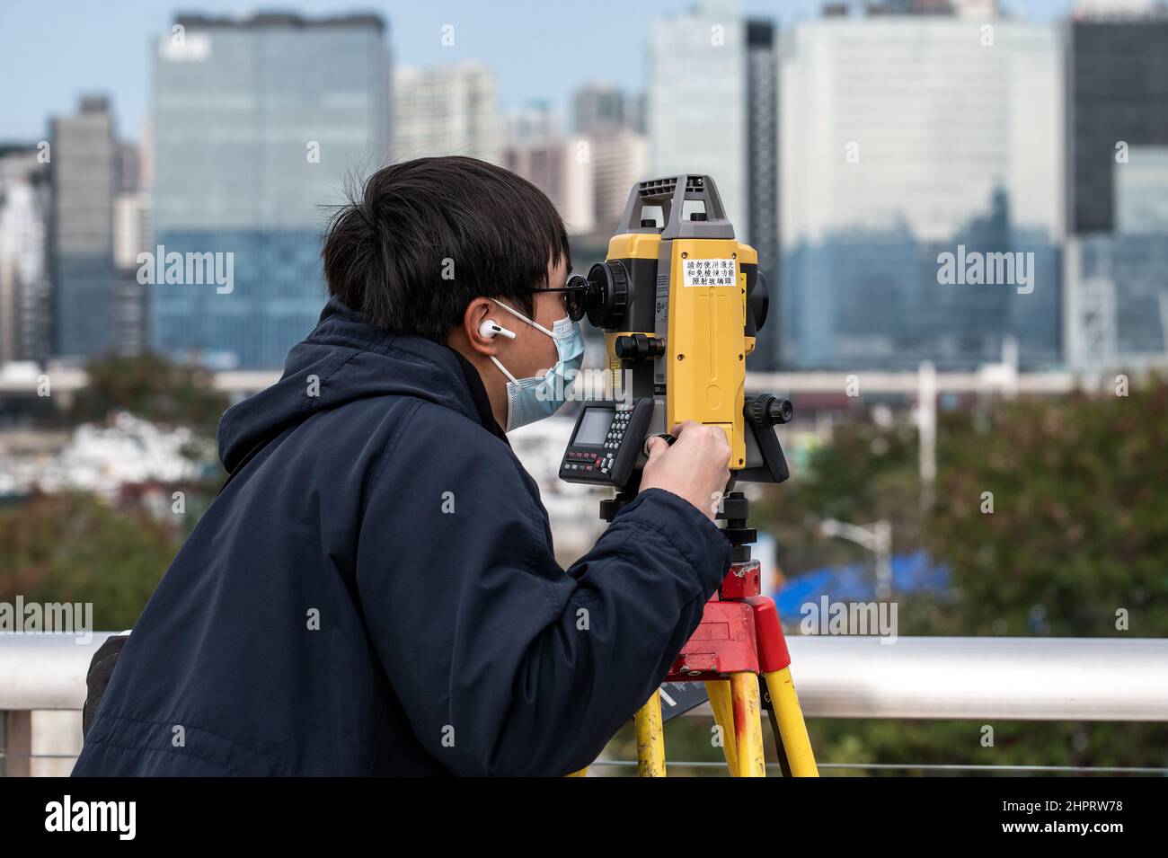 Hong Kong, Hong Kong. 23rd Feb 2022. Un topografo effettua le misurazioni presso il sito di costruzione della quarantena del terminal delle navi da crociera Kai Tak. In tutta Hong Kong si stanno costruendo nuove stazioni di quarantena comunitarie per accogliere il crescente numero di persone che hanno dato risultati positivi al COVID-19. Con una politica per isolare, trattare e, se necessario, ricoverare tutti i pazienti COVID-19 e stretti contatti, il governo di Hong Kong sta creando oltre 10.000 nuovi spazi per l'isolamento e il trattamento. (Foto di ben Marans/SOPA Images/Sipa USA) Credit: Sipa USA/Alamy Live News Foto Stock