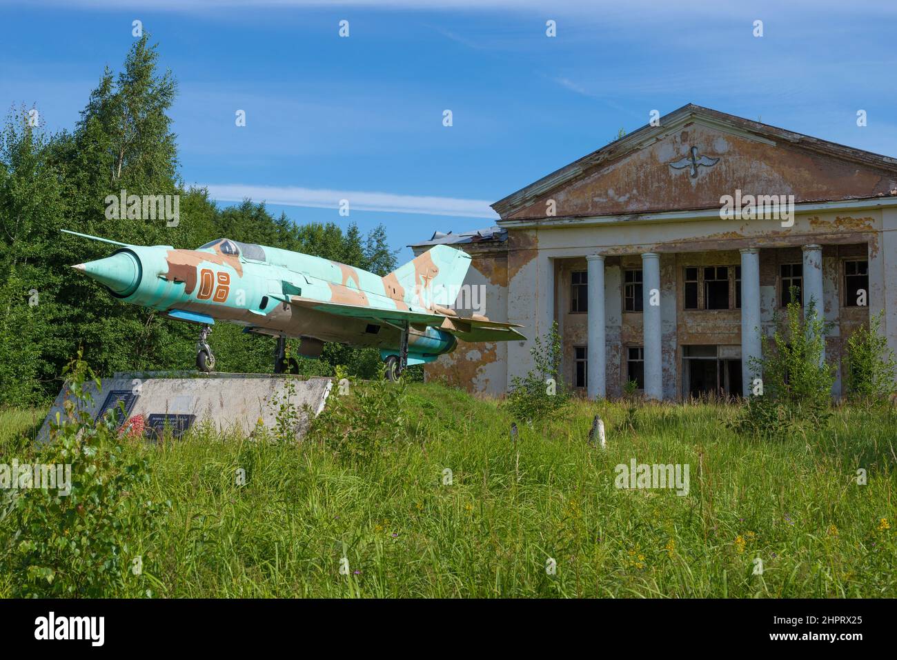 REGIONE DI PSKOV, RUSSIA - 19 LUGLIO 2020: MIG-21 velivolo è un monumento ai piloti militari vicino alla costruzione della Casa della Cultura abbandonata. Territorio Foto Stock