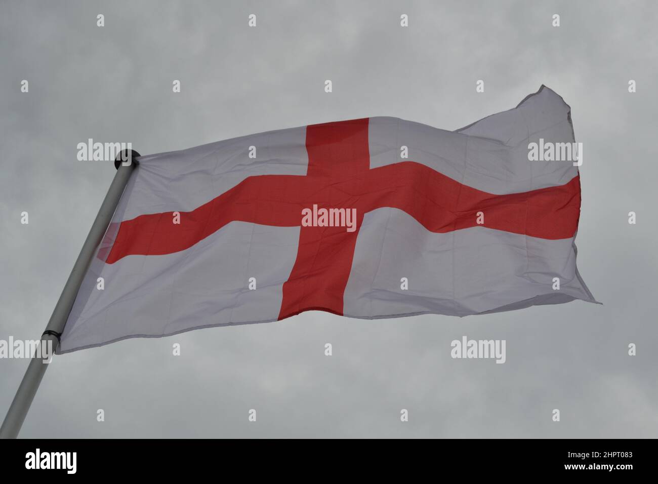 St George's Cross Bandiera Nazionale d'Inghilterra - Wonding in the Wind - Bandiera Rossa + Bianca - Overcast Day -Yorkshire - UK Foto Stock