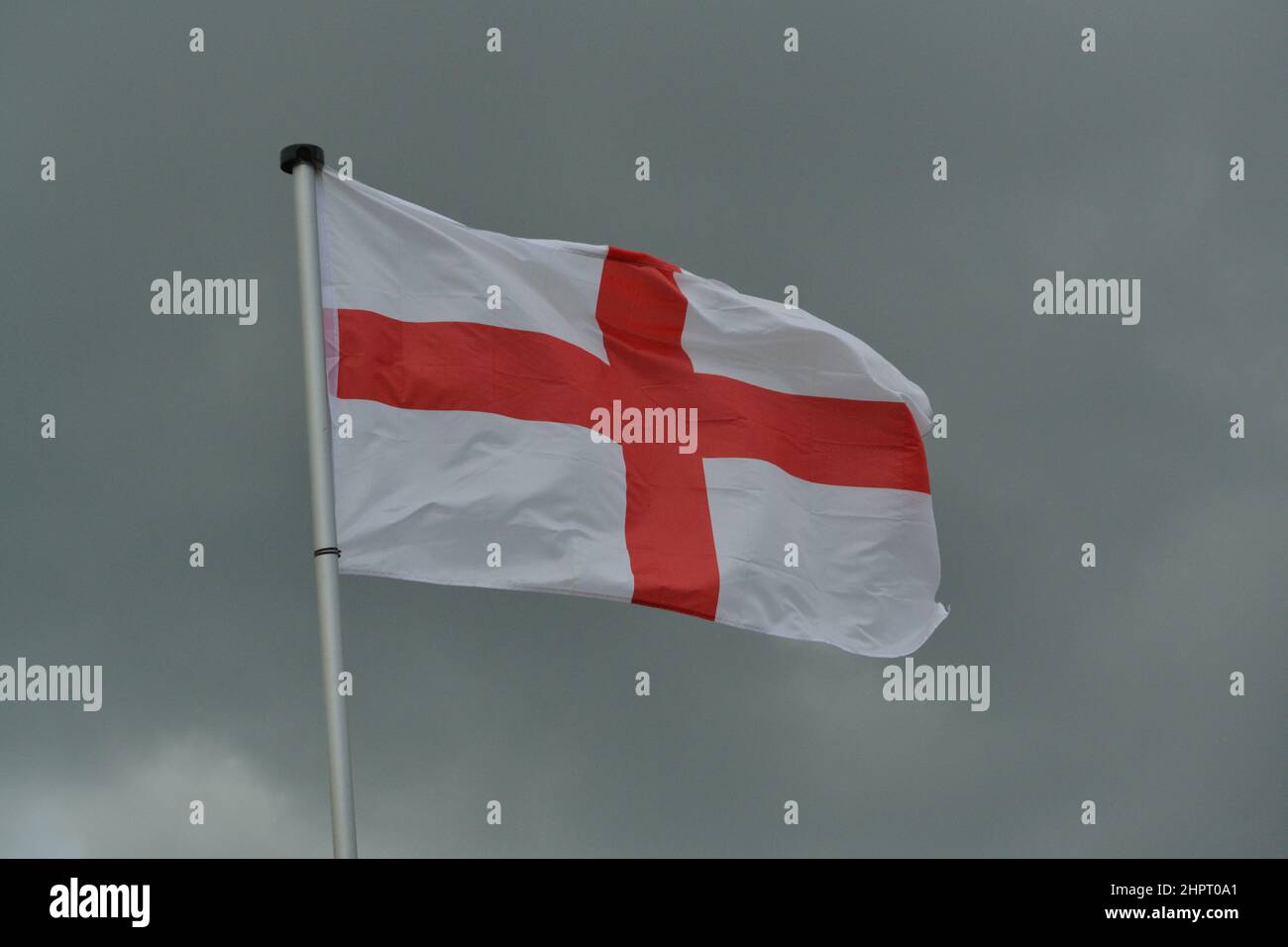 St George's Cross Bandiera Nazionale d'Inghilterra - Wonding in the Wind - Bandiera Rossa + Bianca - Dark Sky - Yorkshire - UK Foto Stock