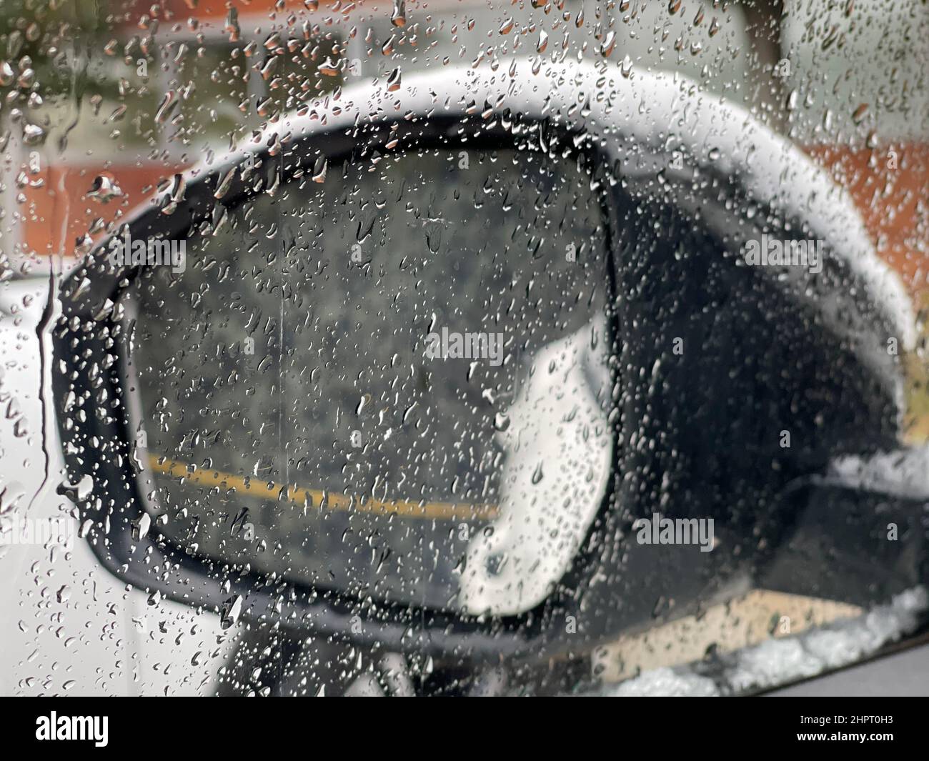 Specchio di un'auto coperta di neve durante la tempesta di neve Foto Stock