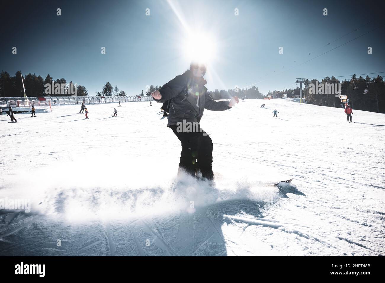 Sciatore che si scia su una pista di sci che alza la neve intorno a lui. Sport invernali. Foto Stock