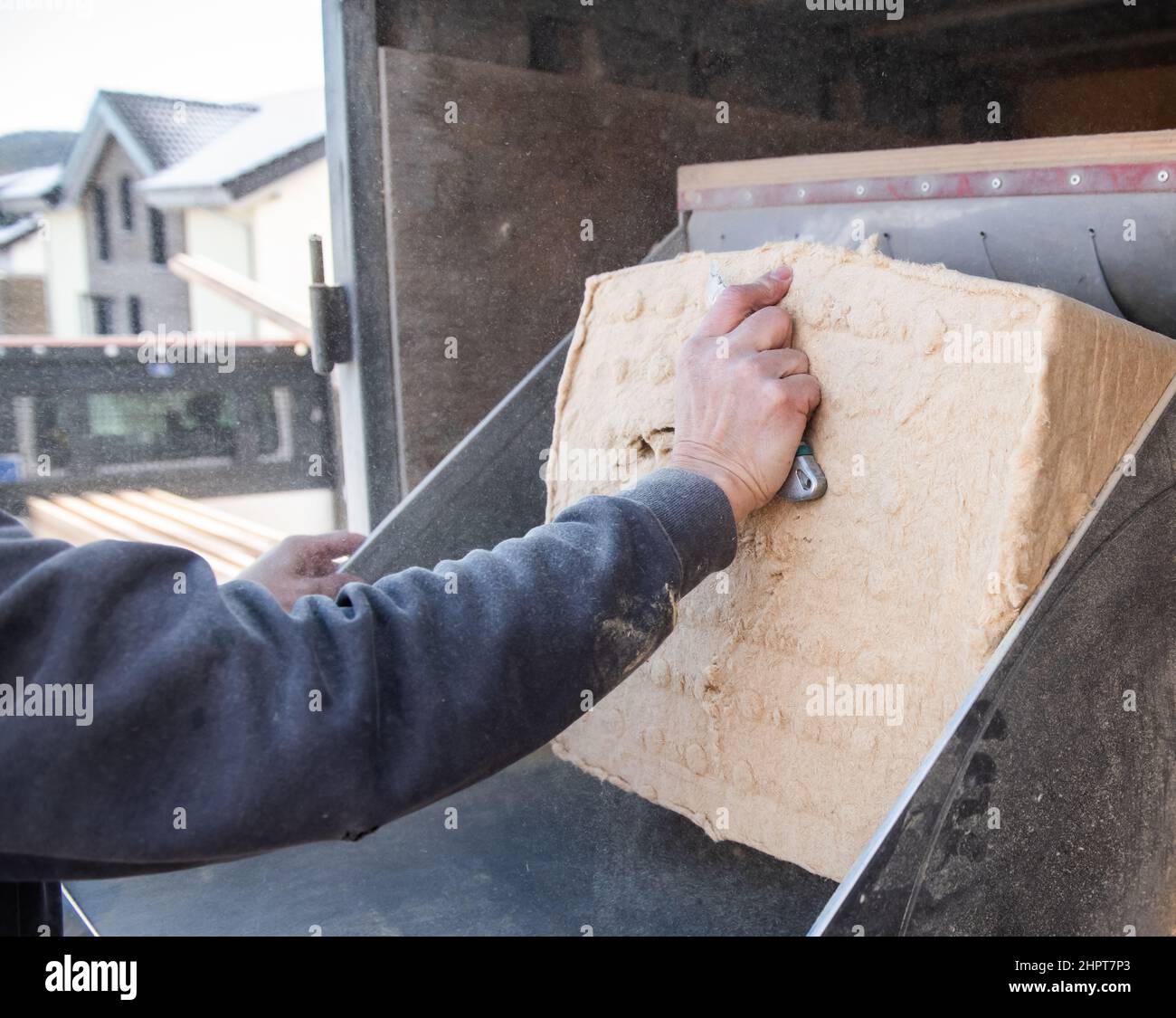 PRODUZIONE - 08 Febbraio 2022, Baden-Wuerttemberg, Schömberg: Una donna spinge il materiale termoisolante in una soffiatrice ad alta capacità. Foto: Silas Stein/dpa Foto Stock