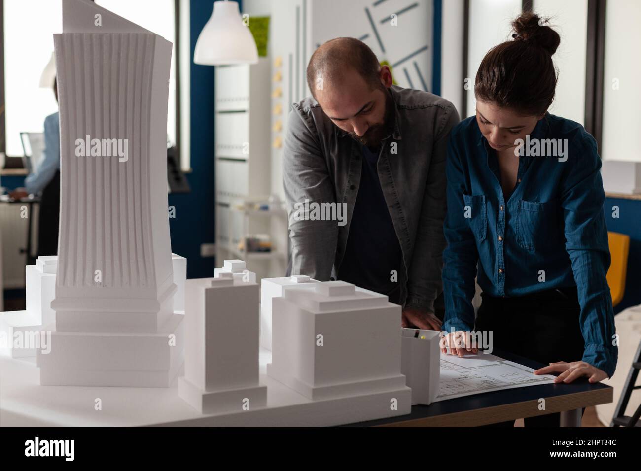 Team di due architetti colleghi che collaborano alla ricerca di progetti di pianificazione urbana. Ingegneri architettonici che fanno lavoro di squadra leggendo i piani di costruzione. Foto Stock