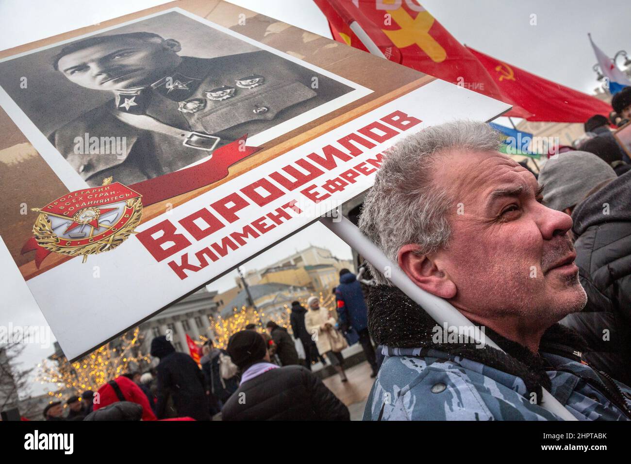 Mosca, Russia. 23 febbraio 2022 Un uomo tiene un ritratto dell'ufficiale militare sovietico e politico Kliment Voroshilov durante una manifestazione del Partito Comunista Russo in Piazza della Rivoluzione nella giornata del difensore della Patria nel centro della città di Mosca, in Russia Foto Stock