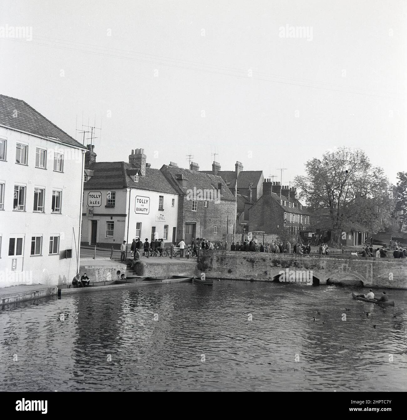 1960s, storici, persone e studenti universitari si sono riuniti al River Cam presso il Mill pub, Mill Lane, Cambridge, Inghilterra, Regno Unito. Persone sul ponte Mill Lane e sul fiume in punt. Foto Stock