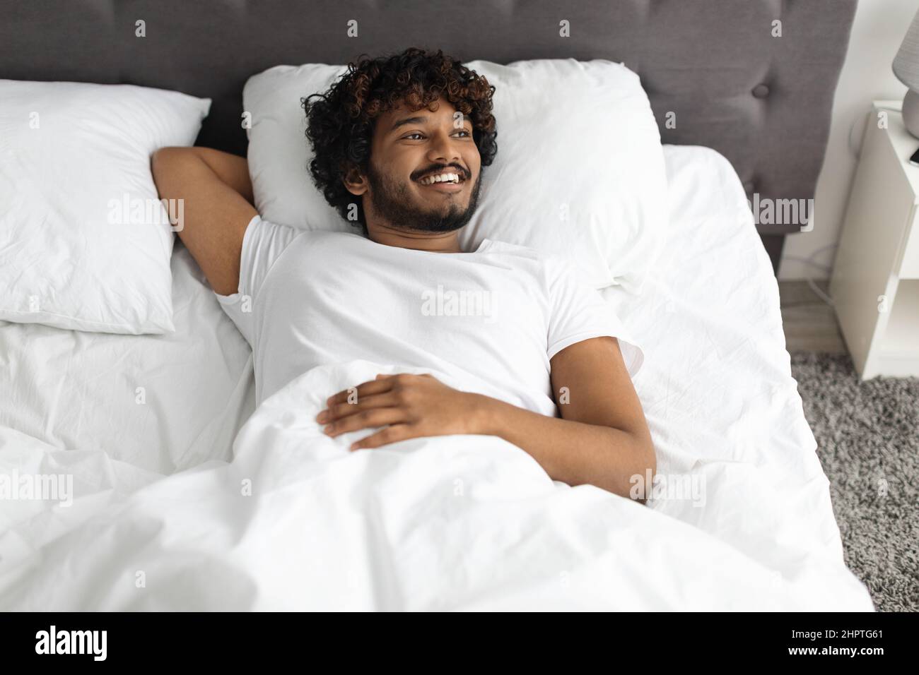 Ragazzo indiano felice godendo buon mattino a letto Foto Stock