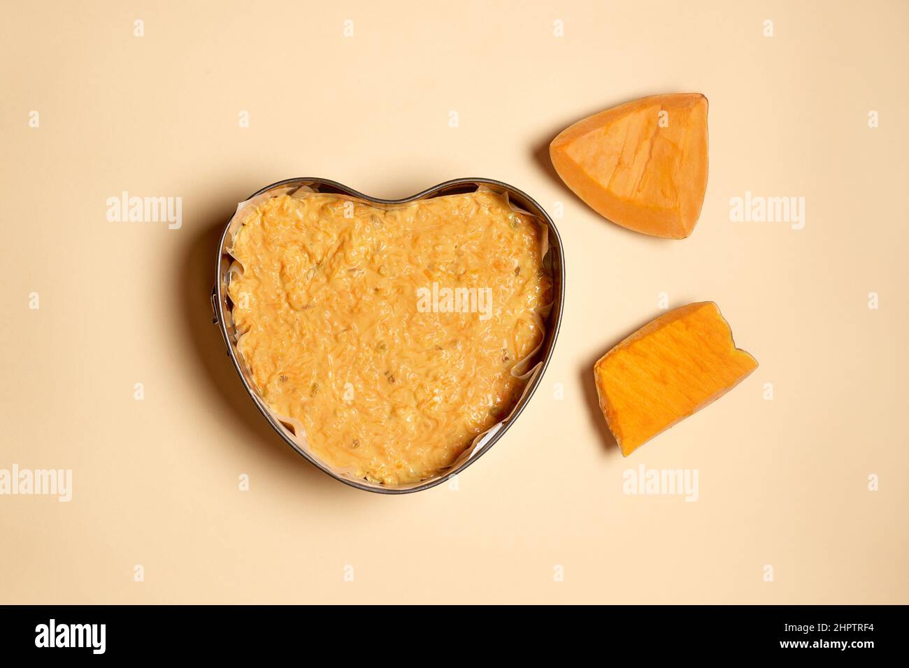 cottura della torta di zucca a casa. tagliare la zucca e l'impasto a forma di cuore su sfondo beige. Istruzioni dettagliate. Punto 1 Foto Stock