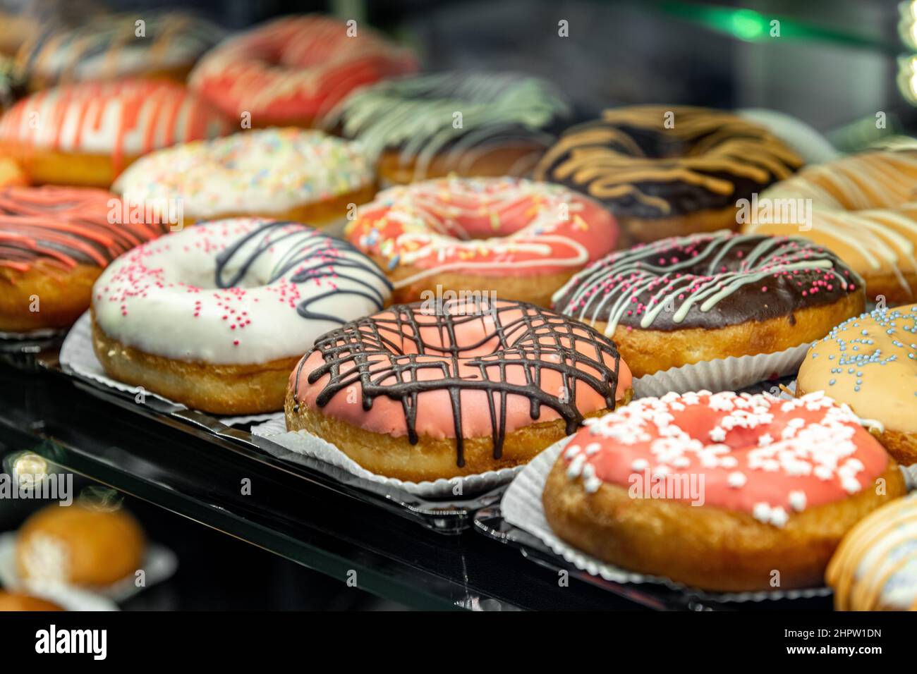 Deliziose ciambelle decorate con diverse decorazioni in vetro del caffè. Fuoco selettivo sfondo sfocato Foto Stock