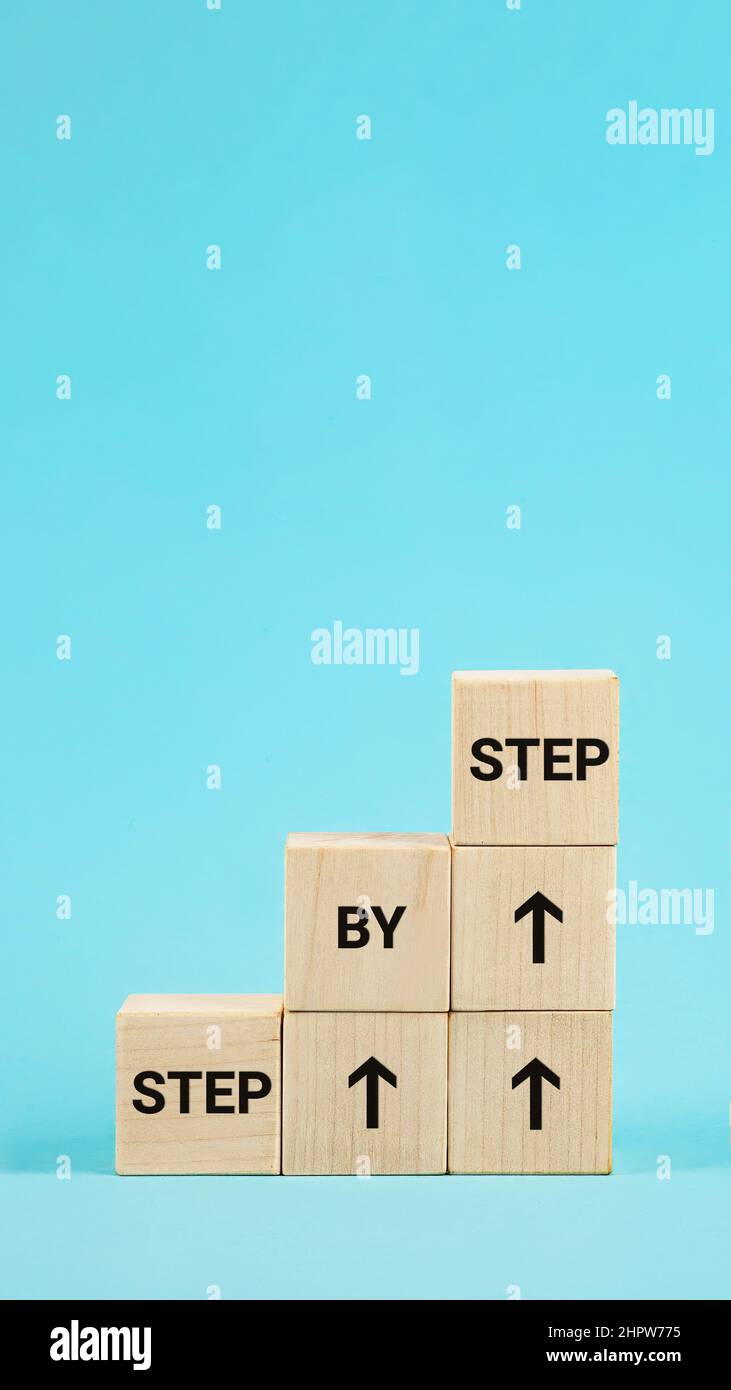 Testo passo per passo. La parola passo dopo passo su cubi di legno. Chid Foto Stock