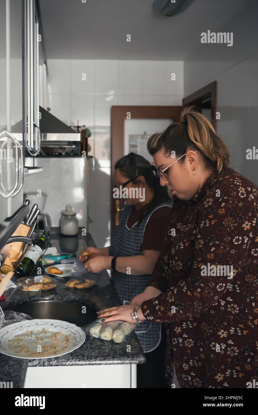 madre anziana che insegna a sua figlia come cucinare Foto Stock