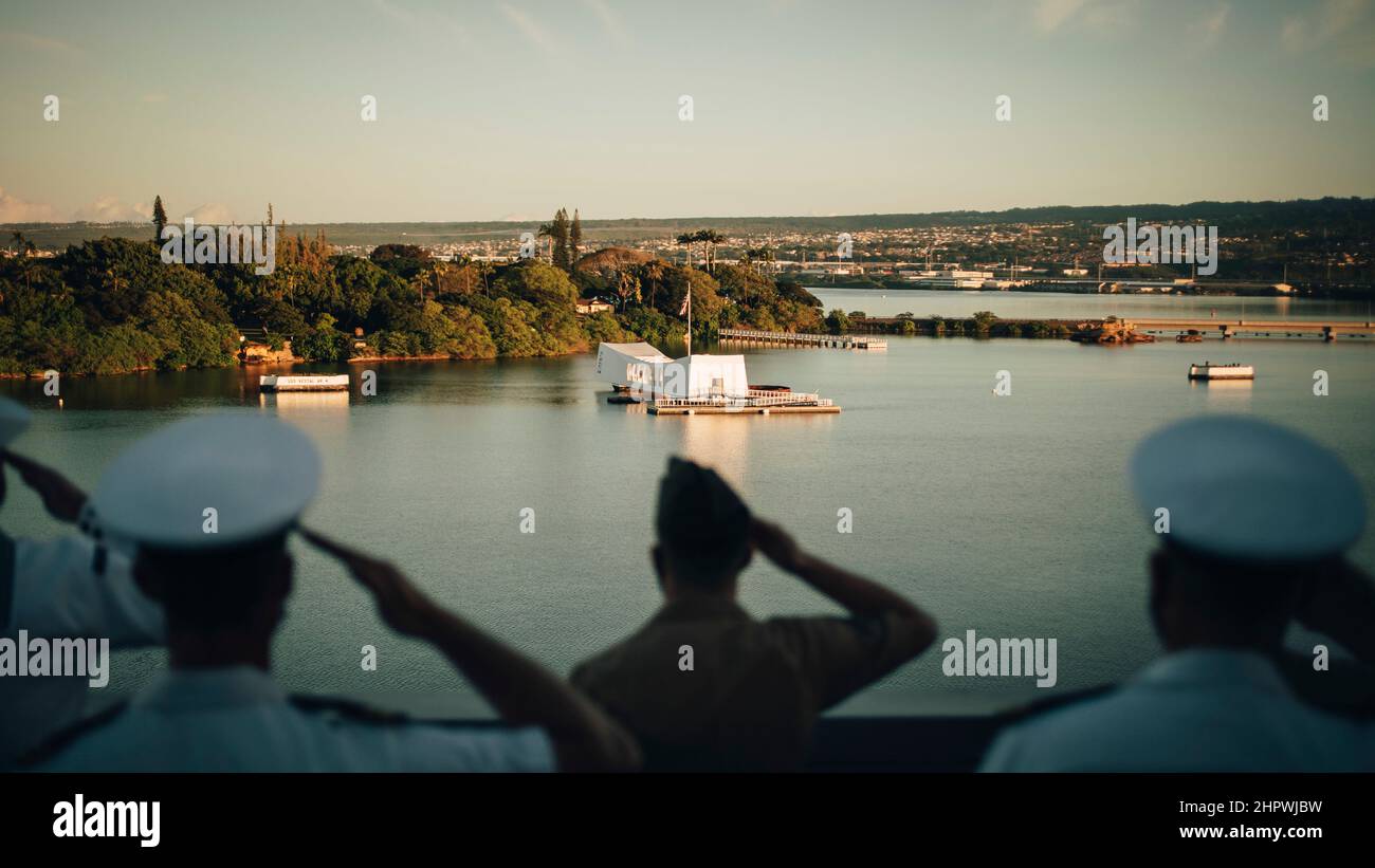 PEARL HARBOR, Hawaii (dal 19, 2022) Marines e marinai assegnati alla 11th Marine Expeditionary Unit (MEU) e il molo di trasporto anfibio USS Portland (LPD 27) salutano il monumento USS Arizona mentre mannando le rotaie come Portland tira in Pearl Harbor, Hawaii, febbraio 19. I marinai e i marinai dell'Essex Amphibious Ready Group (ARG) e del MEU 11th visitano Joint base Pearl Harbor-Hickam mentre operano nella flotta USA 3rd. (STATI UNITI Foto del corpo marino di Gunnery Sgt. Donald Holbert) Foto Stock