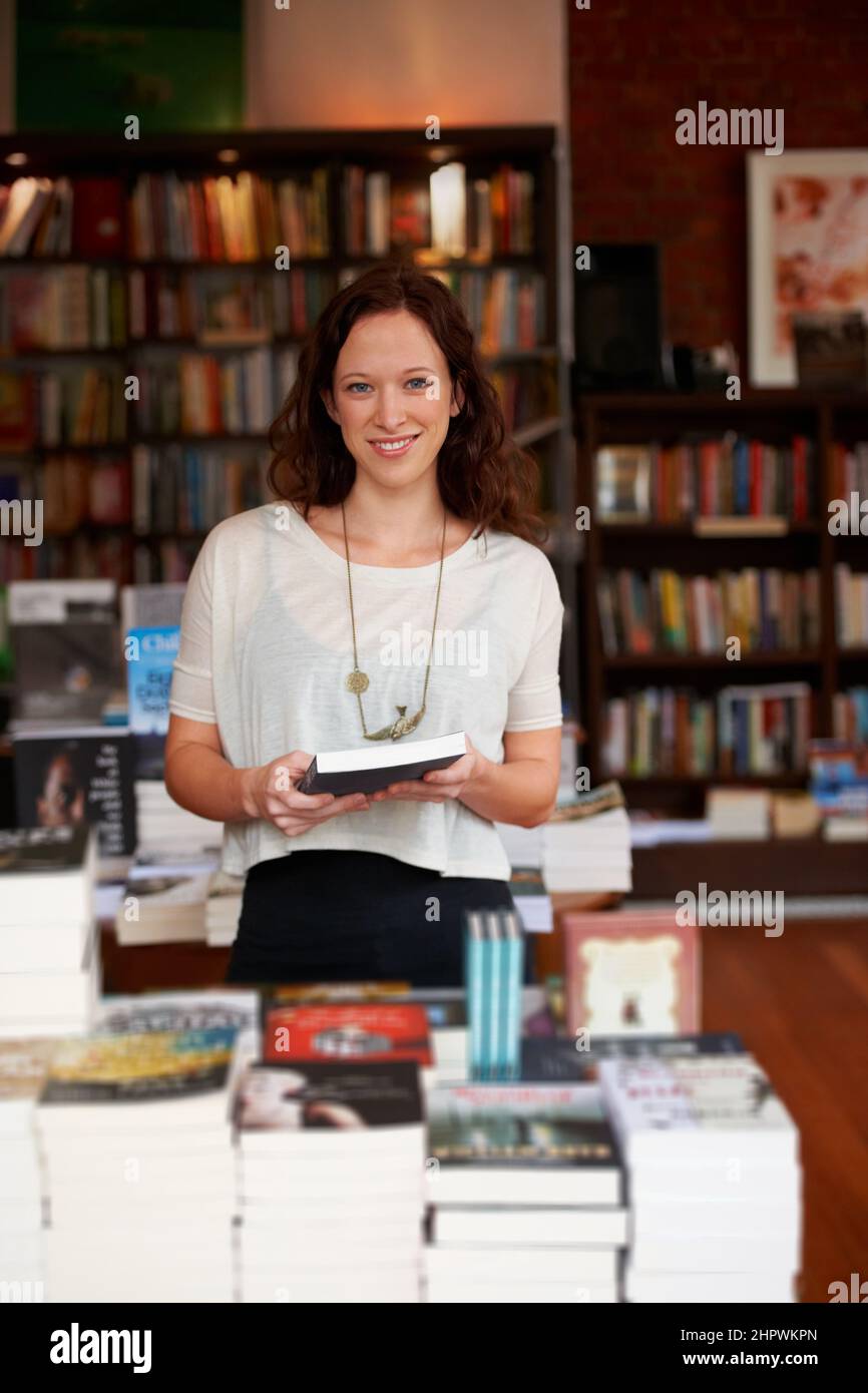 Alla ricerca di quella lettura perfetta. Ritratto di una donna sorridente che naviga in una libreria. Foto Stock