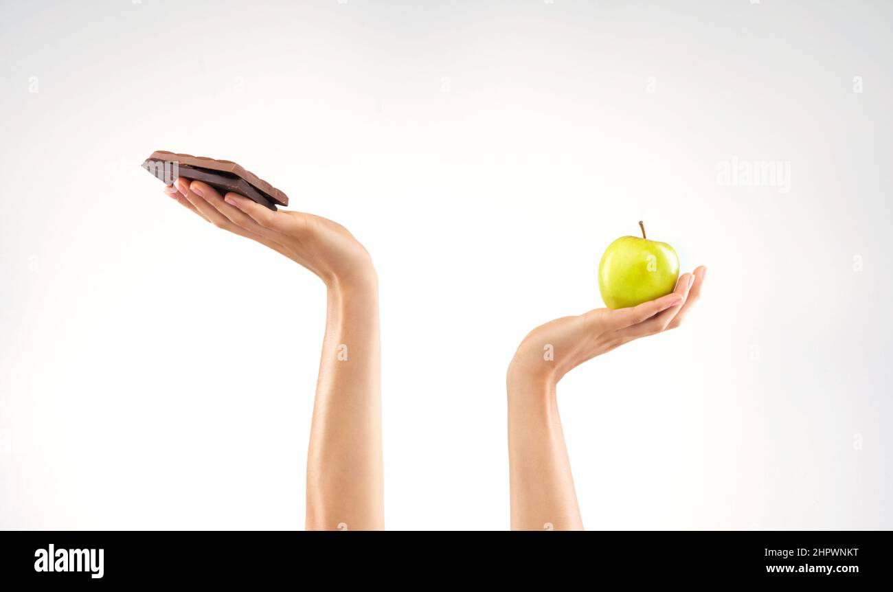 Perché non posso scegliere entrambi. Studio girato di una donna irriconoscibile che decide tra cibi sani e malsani su uno sfondo grigio. Foto Stock Perché non posso scegliere entrambi. Studio girato di una donna irriconoscibile che decide tra cibi sani e malsani su uno sfondo grigio. Foto Stock