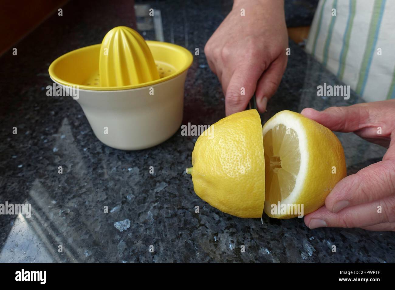 Cottura sveva, preparazione del Cavaissheimer Horaffen, taglio del limone aperto per dolci lieviti, mani da uomo, spremiagrumi dietro, coltello, Germania Foto Stock