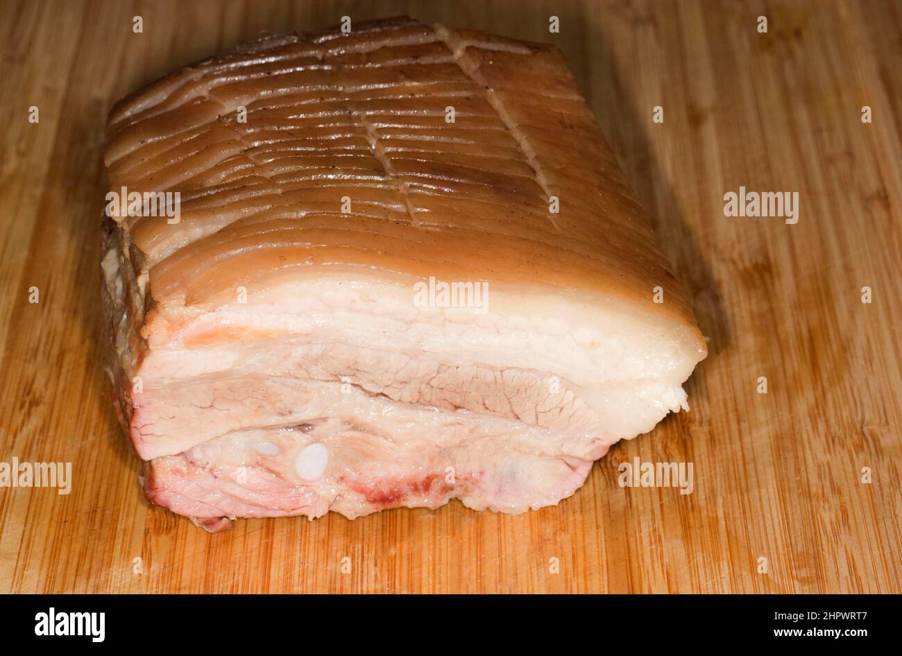 Pancia di maiale precotta su tavola di legno Foto Stock