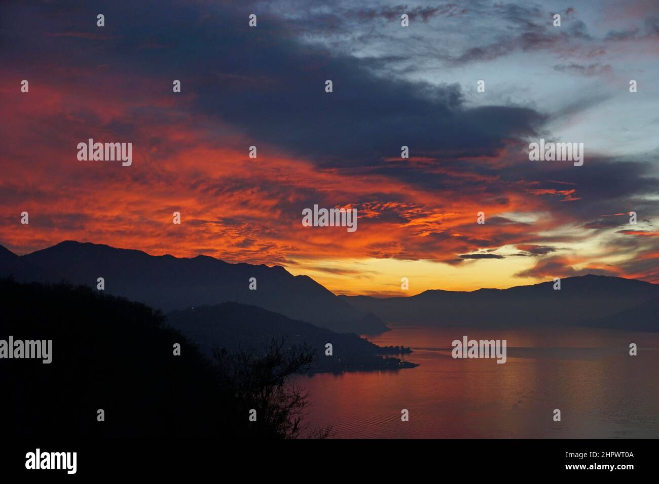 Nuvole rosse incandescenti nel cielo della sera, tramonto sul Lago maggiore, Luino, Lombardia, Italia Foto Stock