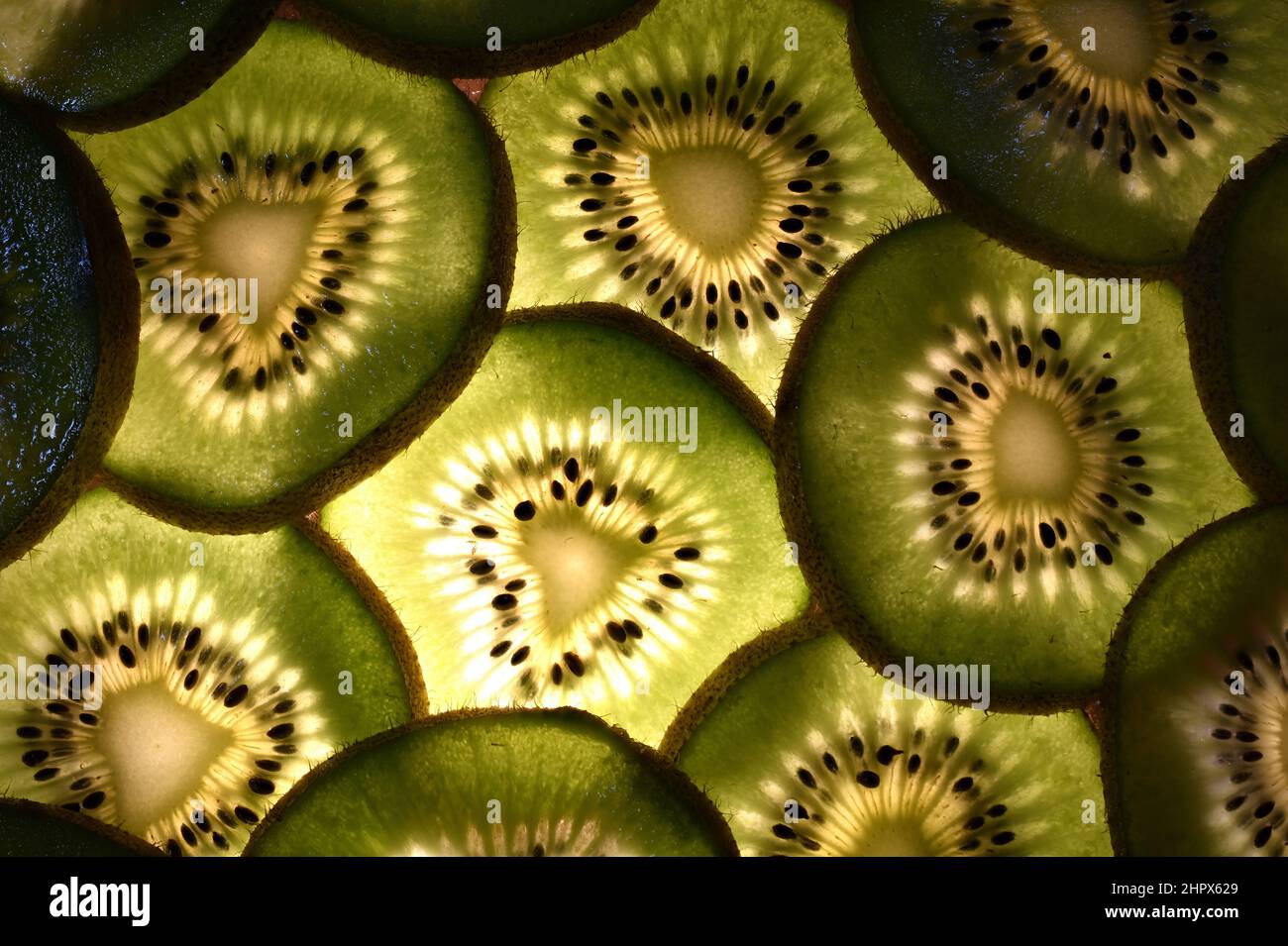Indietro Lime illuminato slice in macro dettaglio che mostrano semi e texture. Foto Stock