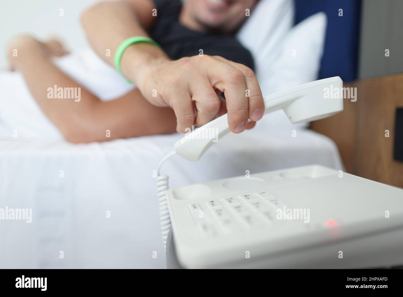 Un uomo mette giù il telefono mentre sdraiato nel letto Foto Stock