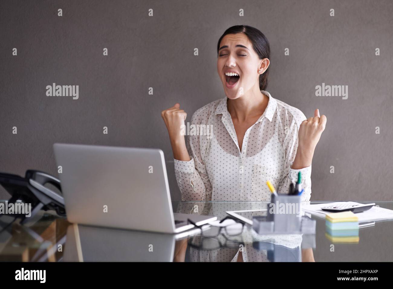 Finalmente è arrivato. Scatto di una bella giovane donna che festeggia al suo portatile. Foto Stock