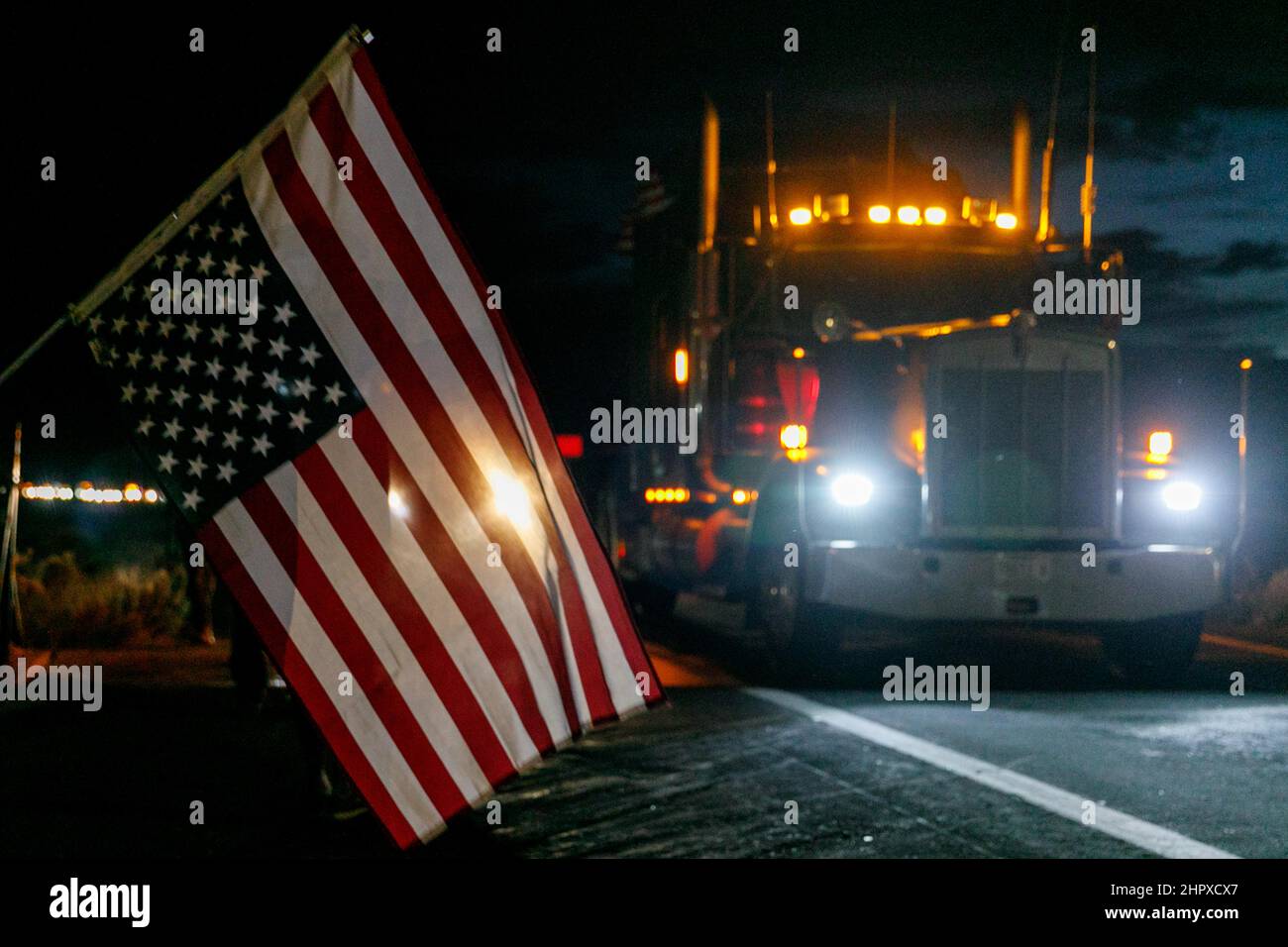 Kingma, Stati Uniti. 23rd Feb 2022. Un segnale di distress invertito della bandiera americana saluta il convoglio a Kingman, AZ. Il convoglio dei camionisti, che oggi conta diverse centinaia di automobili e camion, si avvicina a Kingman, Arizona il 23 febbraio 2022. (Foto di John Rudoff/Sipa USA) Credit: Sipa USA/Alamy Live News Foto Stock
