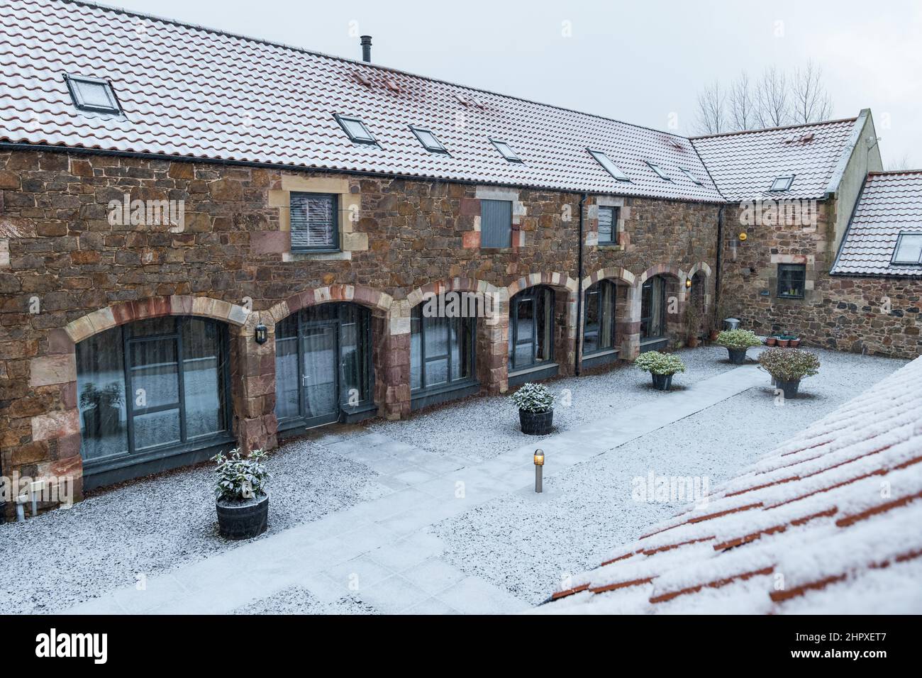 East Lothian, Scozia, Regno Unito, 24th febbraio 2022. UK Meteo: Neve che cade su case di stadatura convertite in inverno Foto Stock