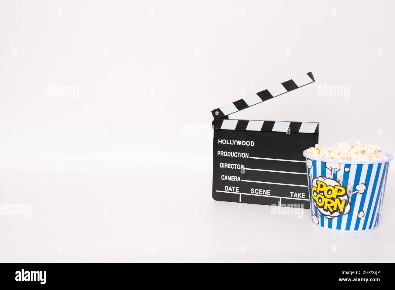 Black Clapper board o film ardesia e popcorn su sfondo bianco. Foto Stock