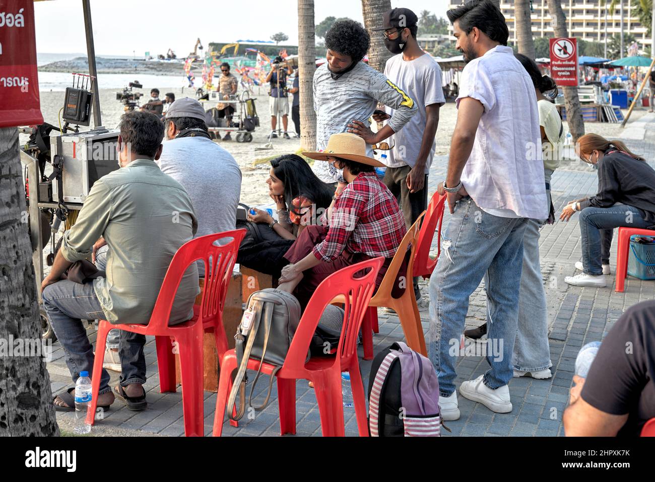 Produzione cinematografica di Bollywood presso una spiaggia all'aperto con i membri del cast che rivedono il film. Foto Stock