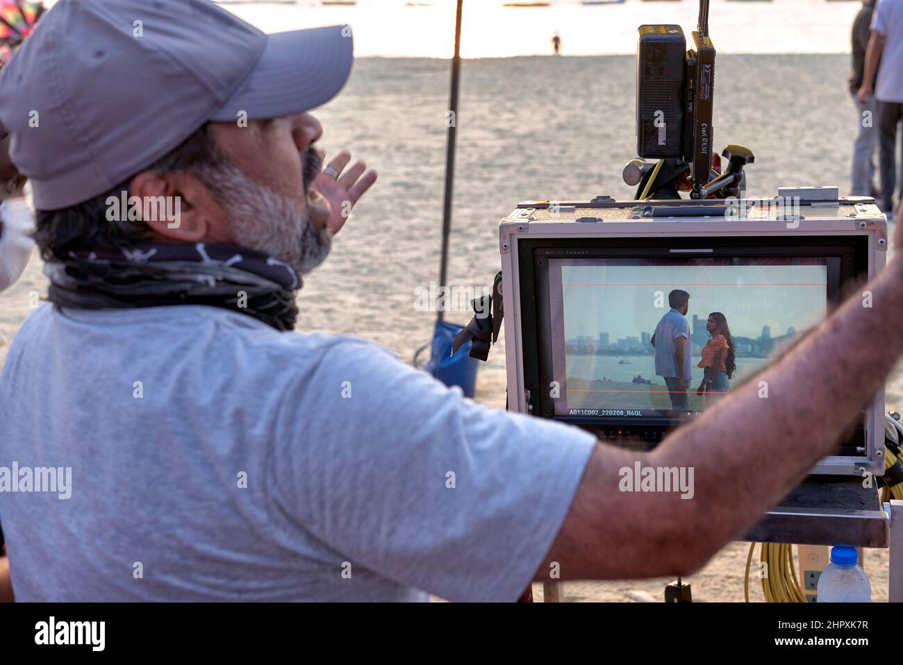 Il produttore di film di Bollywood filma all'aperto e guarda la produzione attraverso un monitor. Foto Stock