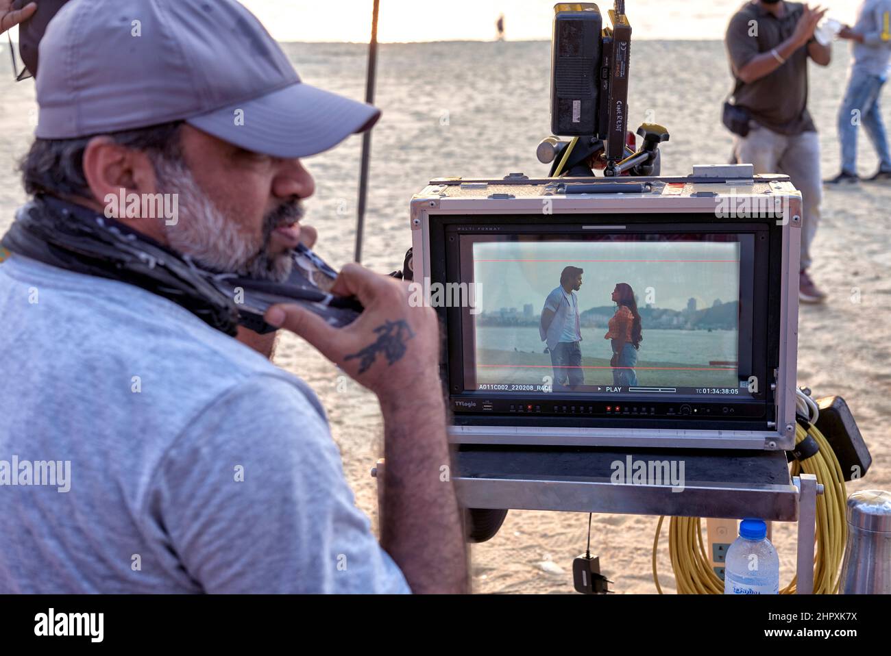 Il produttore di film di Bollywood filma all'aperto e guarda la produzione attraverso un monitor. Foto Stock