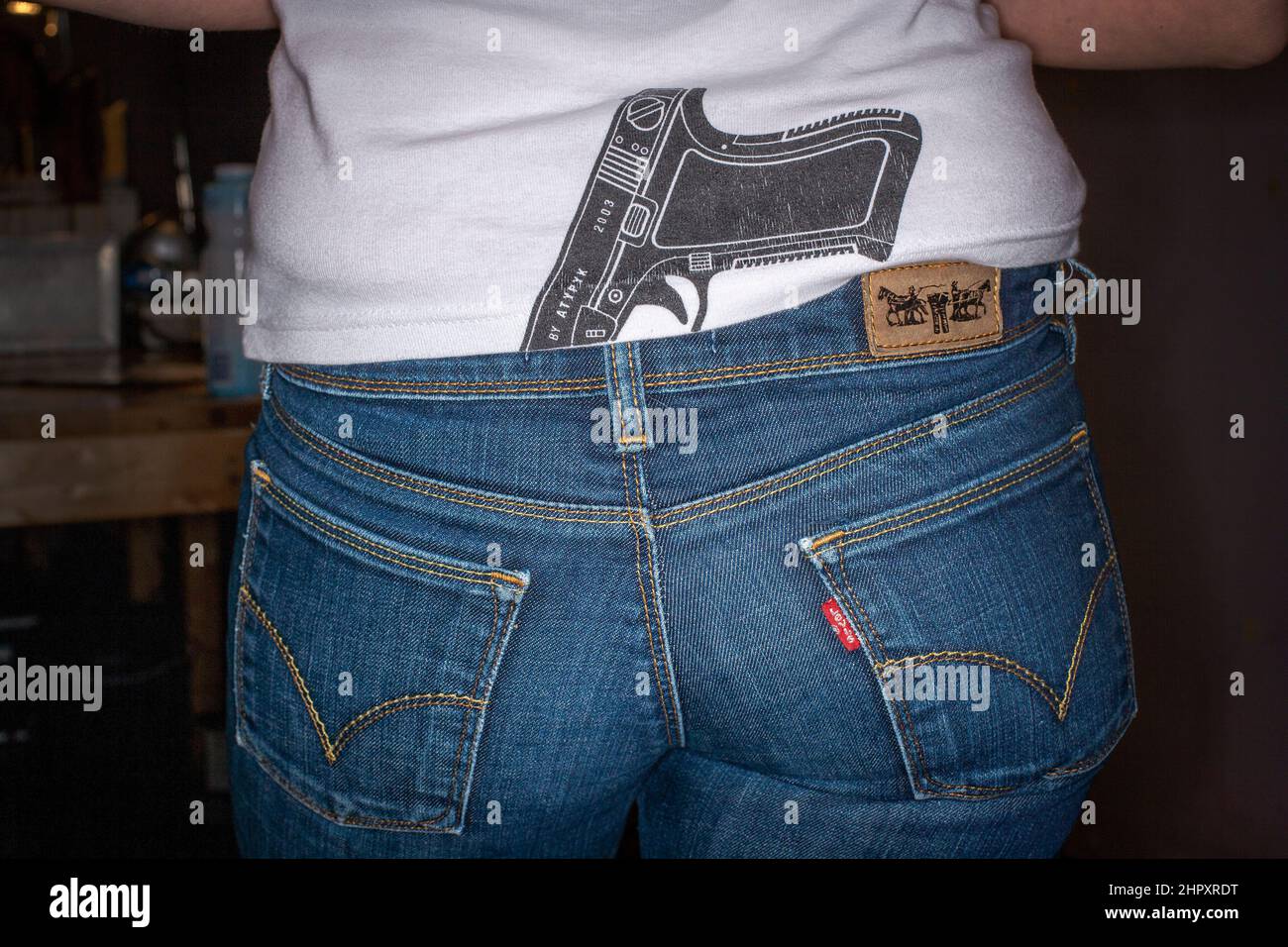 pistola nel suo pantaloni t-shirt Foto Stock