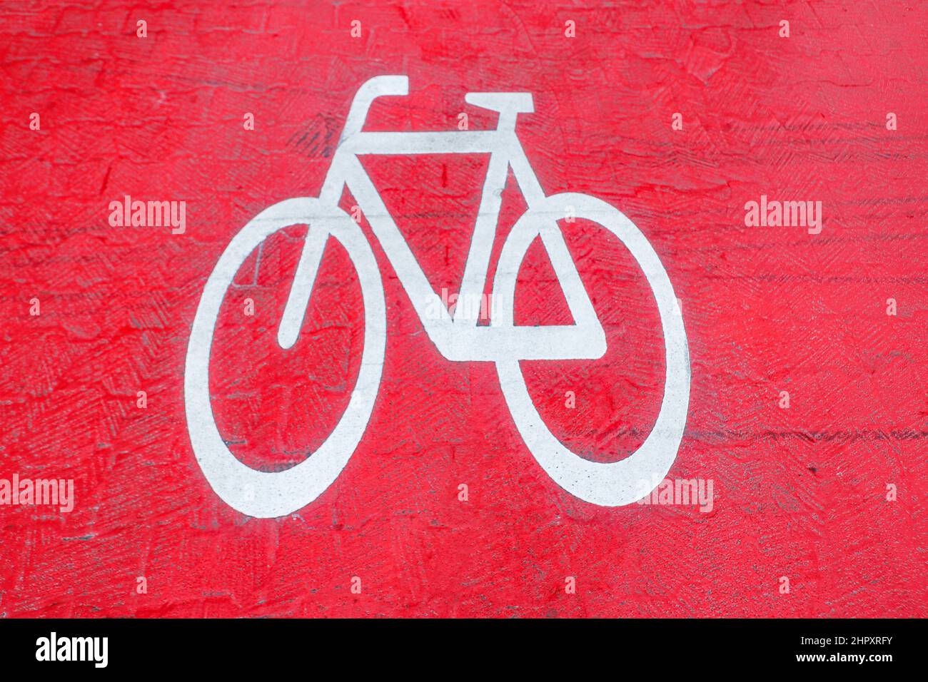 icona bianca bicicletta strada all'asfalto rosso in una strada principale Foto Stock