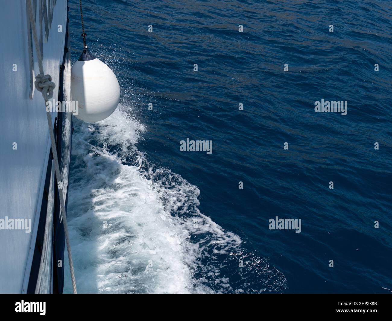 La boa pende dalla nave mentre naviga sul mare Foto Stock