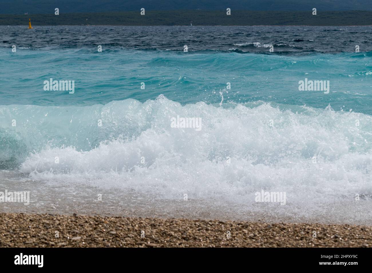 Mare ondulato sulla spiaggia Zlatni rat vicino Bol città sull'isola di Brac in Croazia Foto Stock
