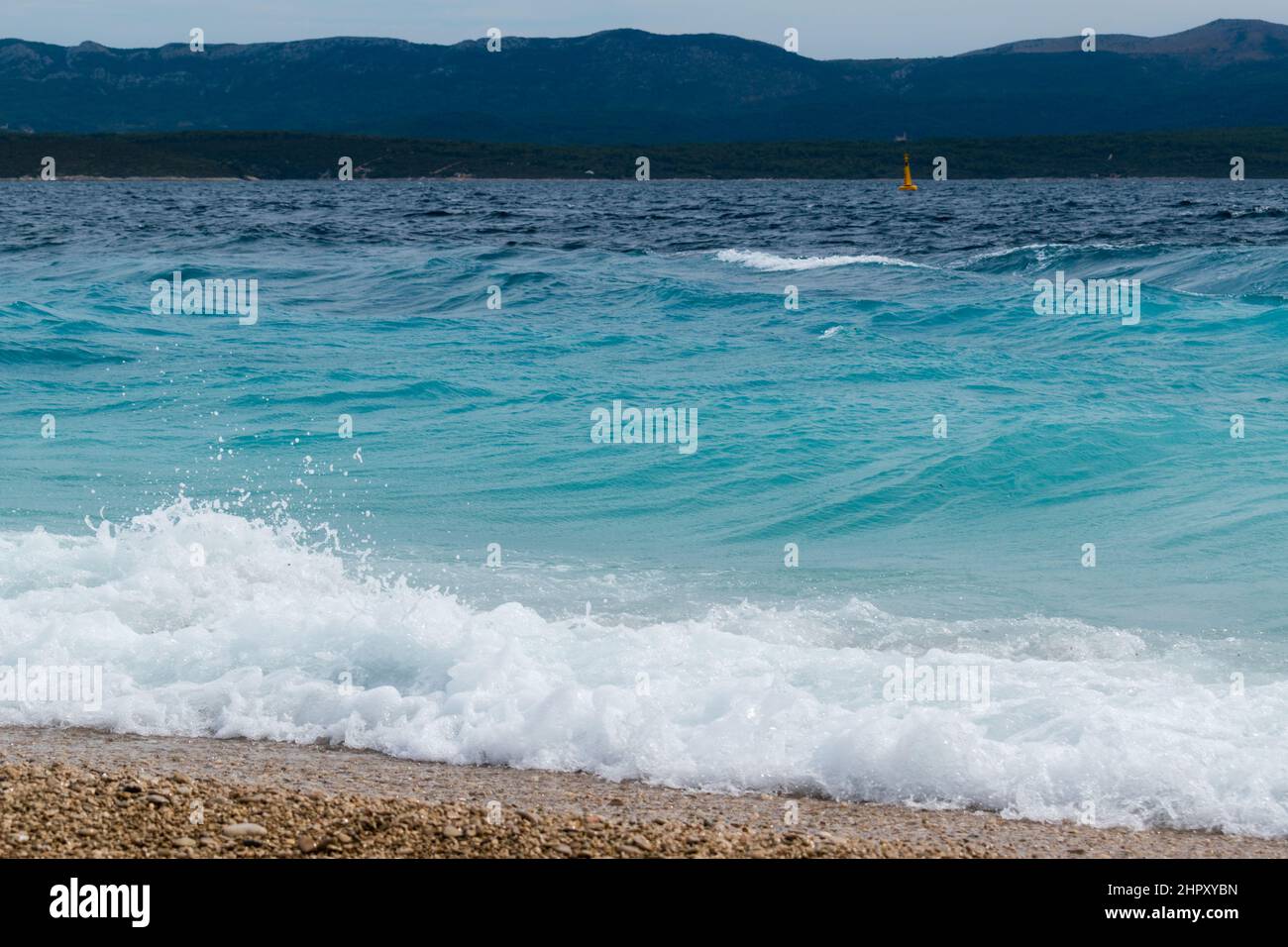 Mare ondulato sulla spiaggia Zlatni rat vicino Bol città sull'isola di Brac in Croazia Foto Stock