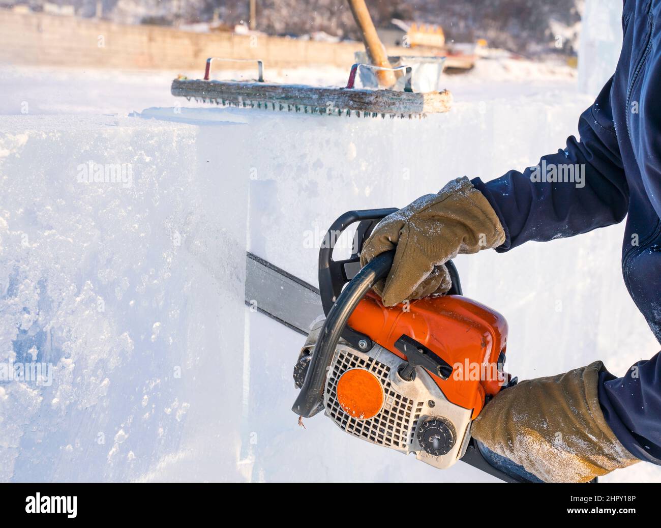 Lo scultore taglia una forma da un blocco di ghiaccio con una sega a benzina sul lago Baikal. Foto Stock